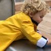 Yellow children's rain coat with black and white cuffs